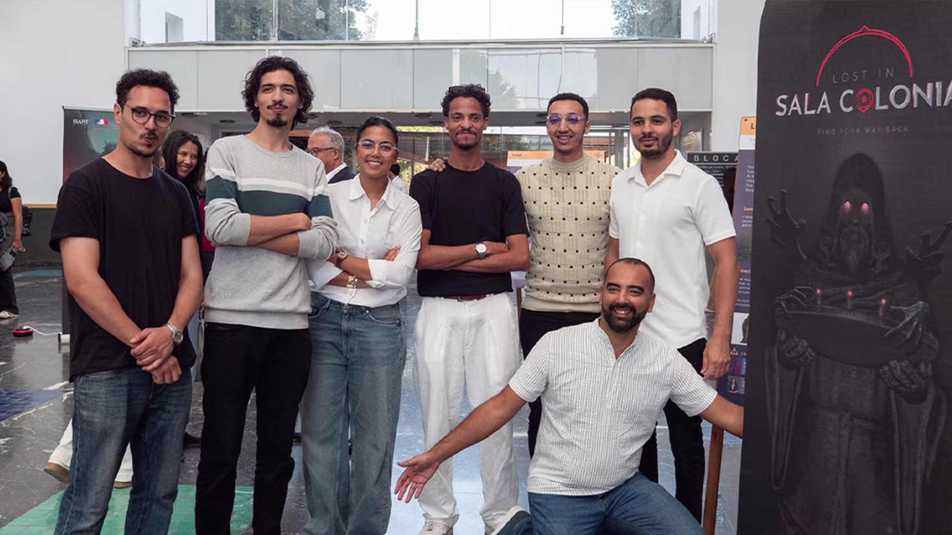 Lost In SalaColonia team beside the game poster at ISART Talents