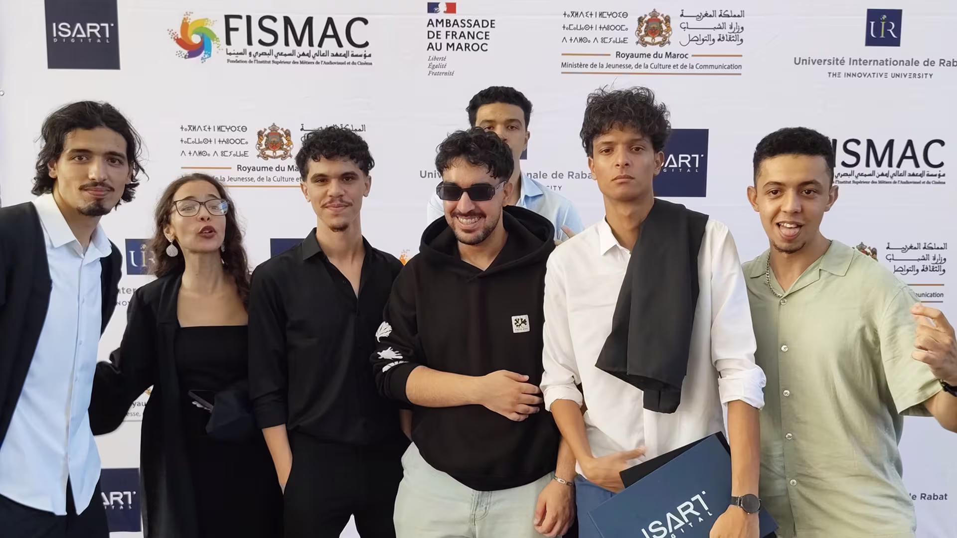 Video Game Creator graduates posing at the ISMAC backdrop